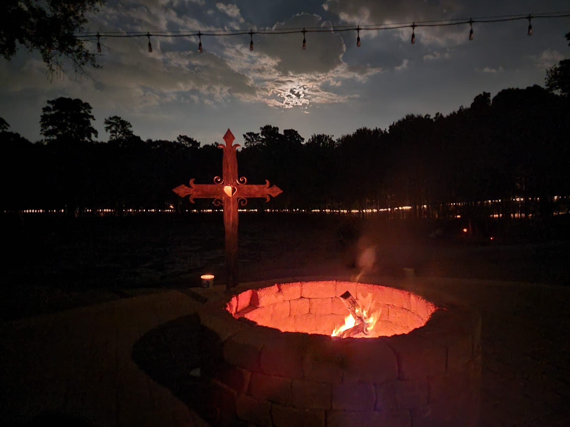 Cross and fire pit under moonlight